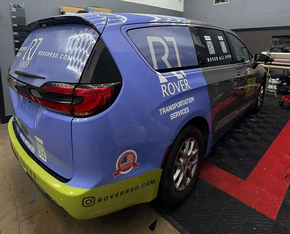 ROVER-branded Pacifica with blue and green vehicle graphics and removable advertising signage.